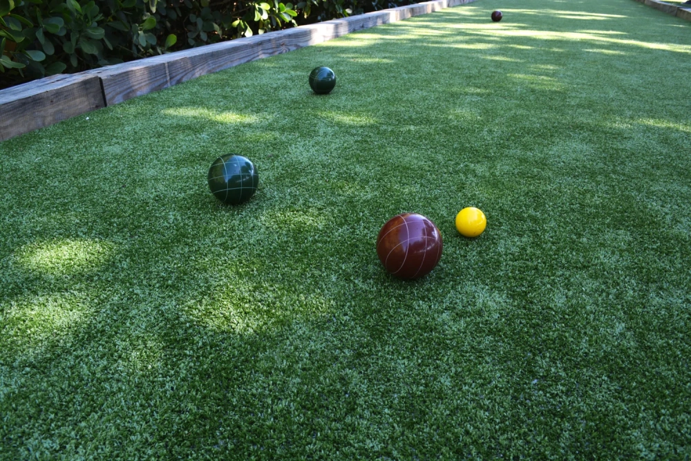 Outdoor bocce ball court built with artificial turf in a residential backyard