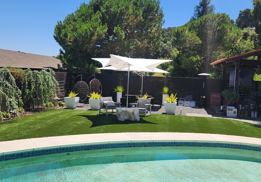 artificial grass lawn with table chairs and umbrella on it